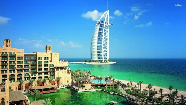 Burj Al Arab luxury hotel with beachfront resort, palm trees, and turquoise sea in Dubai
