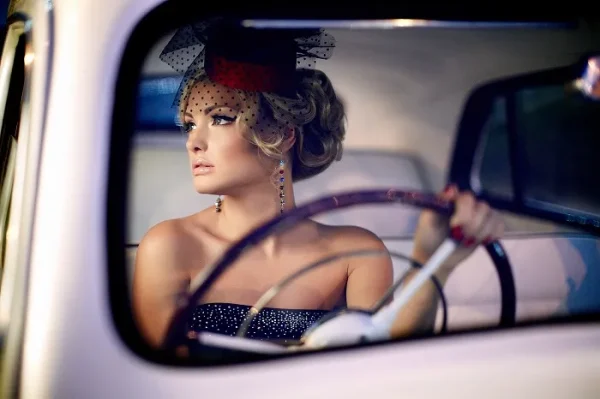 Elegant woman in a classic luxury car wearing sophisticated fashion and accessories