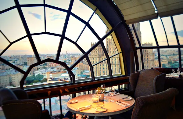 Luxury rooftop restaurant overlooking a city skyline through panoramic windows