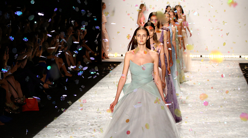 confident woman in a glittering dress walking down the catwalk