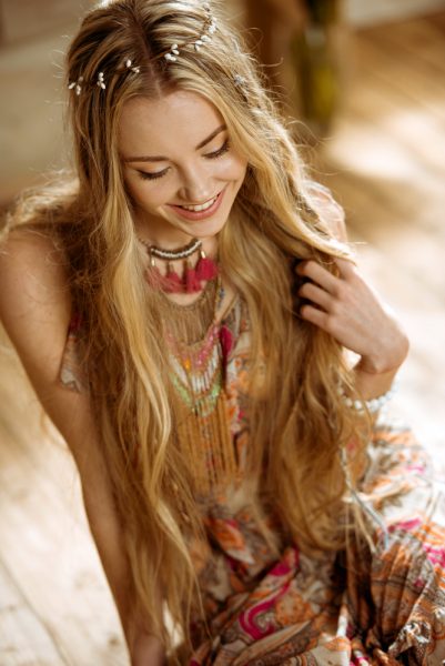 laughing woman with long curly blond hair wearing a sparkly dress