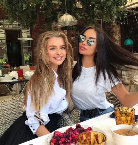Two elegant women enjoying lunch at a stylish outdoor café, representing friendship, luxury lifestyle, and social experiences