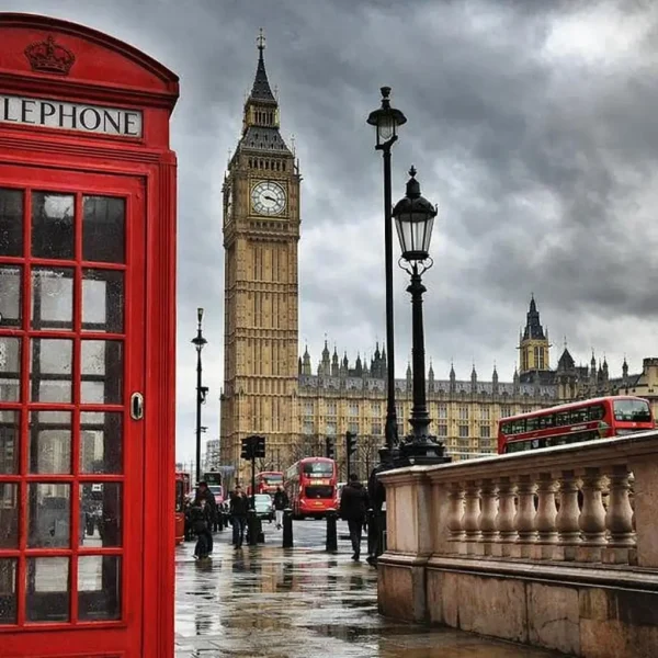 elegant woman walking through london street with red telephone booth in background