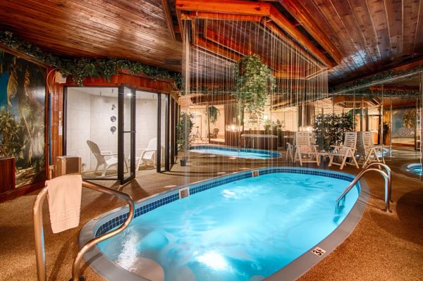 luxurious couple clinking champagne glasses in golden lit spa