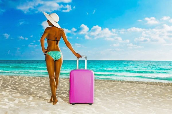 Stylish woman arriving on a Maldivian beach — elite travel companion in a tropical escape