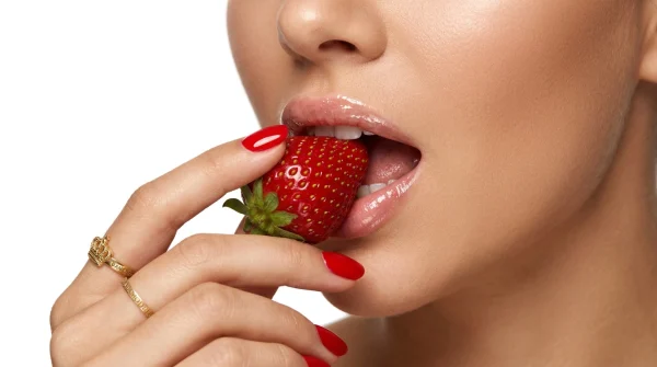 close-up of a woman’s lips with her finger touching them